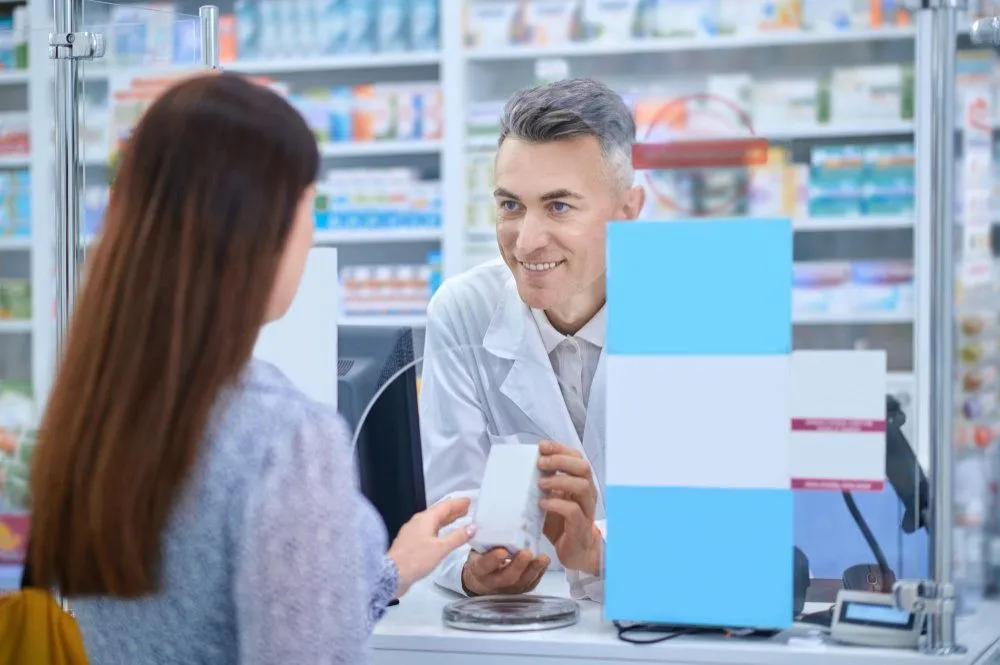 female client standing near pharmacy counter
