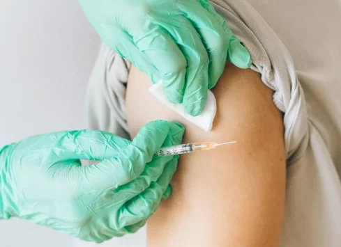 A person is getting a vaccine in their arm.